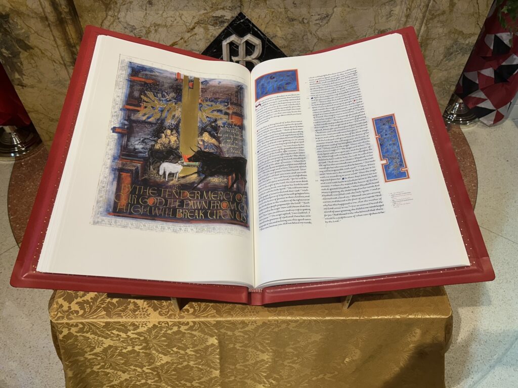 The Saint John's Bible lays open to an illumination of the nativity, featuring a swath of gold and animals