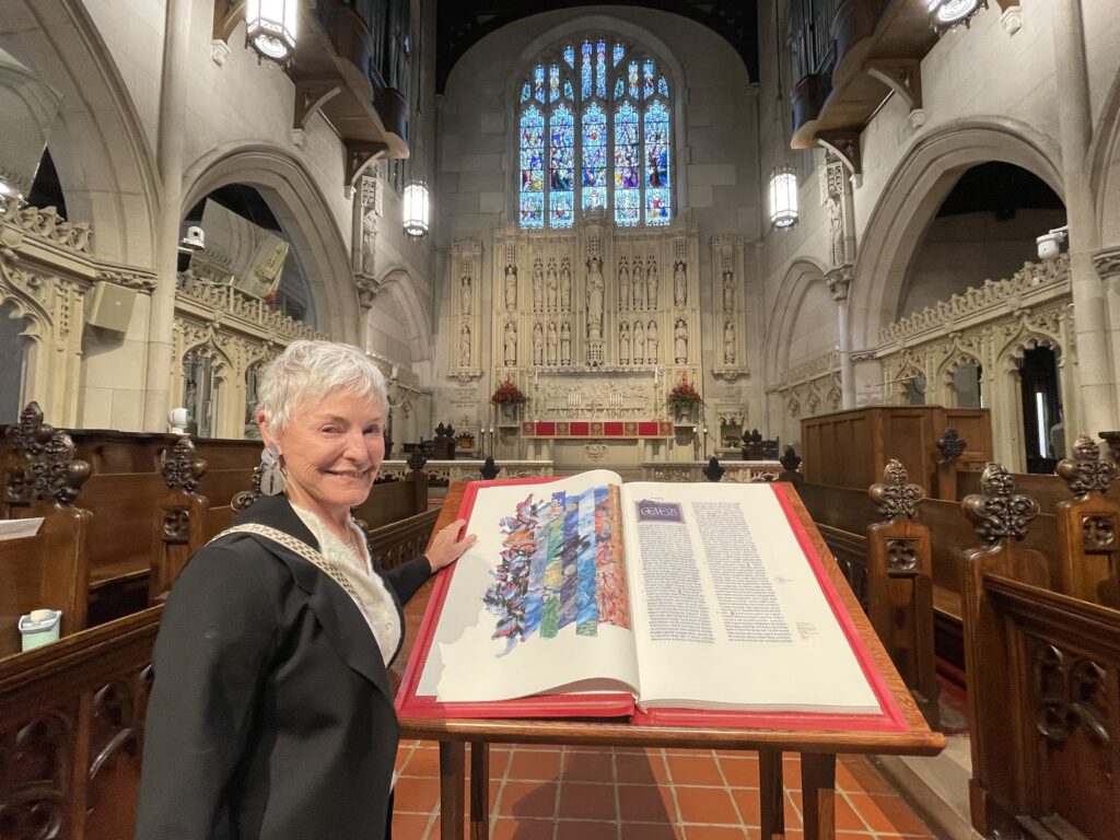 a women stands next to the saint john's bible