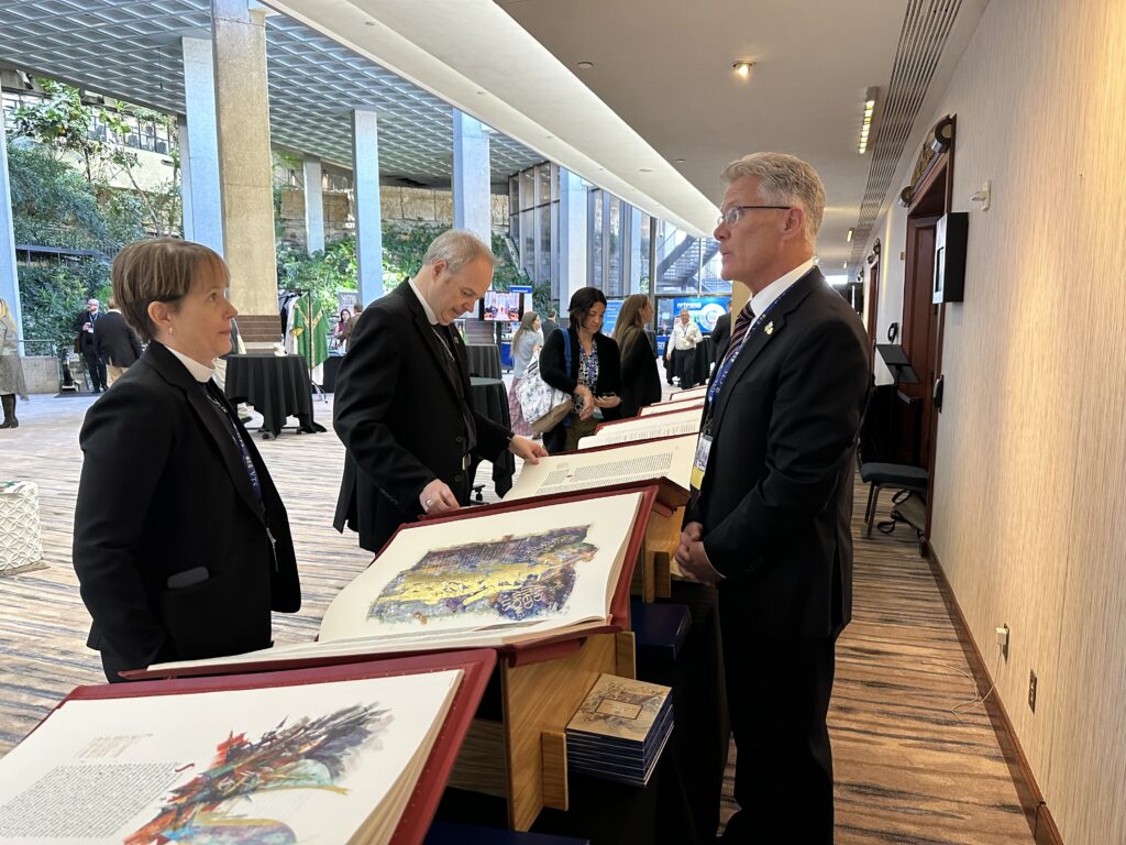 Brad Neary shares the Heritage Edition with The Rev. Molly James and Presiding Bishop The Most Rev. Sean W. Rowe during the 2025 Episcopal Parish Network Conference.