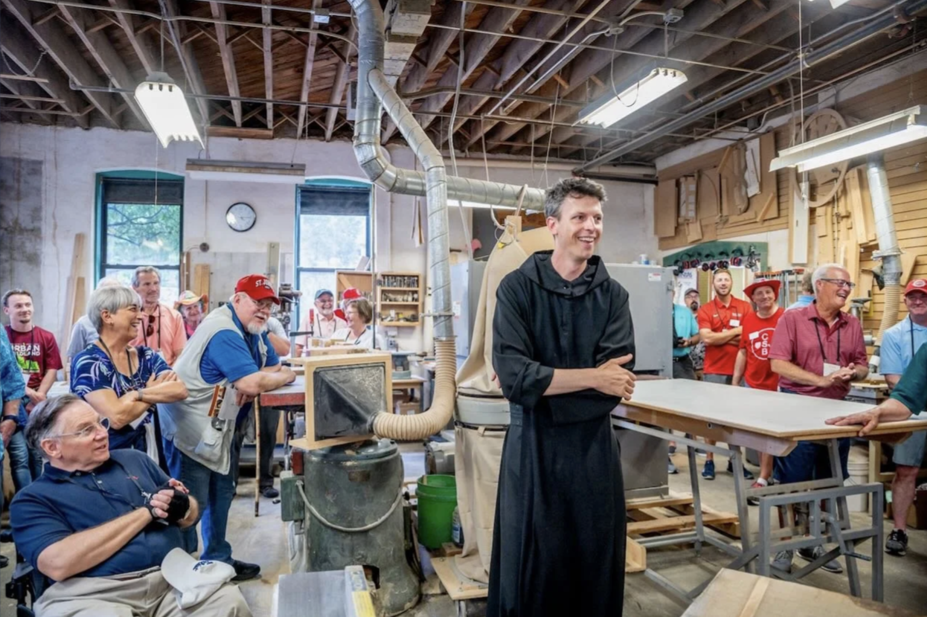 Fr. Lew Grobe, O.S.B., giving a tour in the old Abbey Woodshop. 