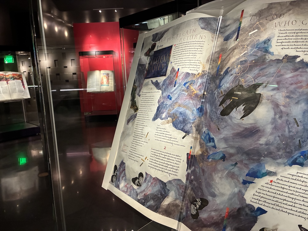 a page open to the scripture of Ecclesiastes filled with purple and blue imagery, crows and butterflies flying across the page